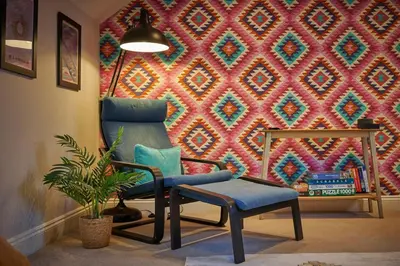 a living room with a chair and a wall at Riverside Park 5 in Keswick