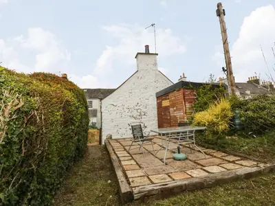 a garden with a table and a bench in front of a house at 2 Fleet Street in Castle Douglas