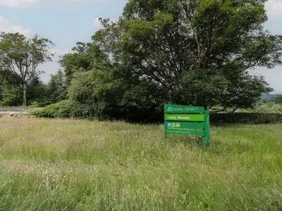 a green sign in the middle of a field at 2 Fleet Street in Castle Douglas