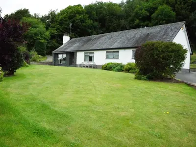 a white house with a large lawn in front of it at Dale View in Cockermouth