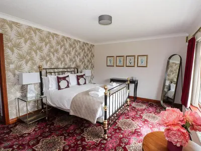 a bedroom with a bed and a pink carpet at Dale View in Cockermouth