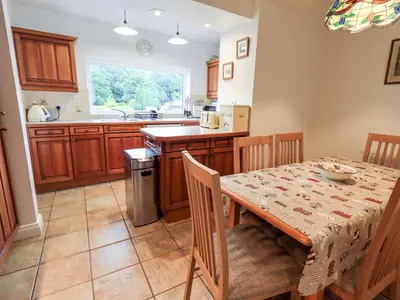 a kitchen with a dining room table and a table and chairs at 7 Stybarrow Terrace in Penrith