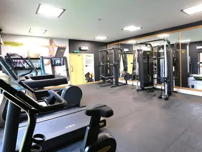 a gym with several treadmills and machines at Honeybee Cottage in Penrith