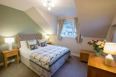 a bedroom with a bed and a window at Honeybee Cottage in Penrith