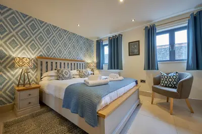a bedroom with a bed and a chair at Riverside Park 2 in Keswick