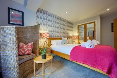 a bedroom with a large bed and a chair at Riverside Park 4 in Keswick
