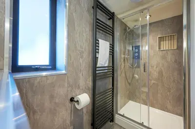 a bathroom with a shower and a toilet paper roll at Riverside Park 4 in Keswick