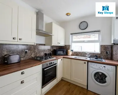 a kitchen with white cabinets and a washer and dryer at NEW Four Bedroom House By Keysleeps Short Lets Workington Contractor Leisure Beach Location Lake District in Siddick