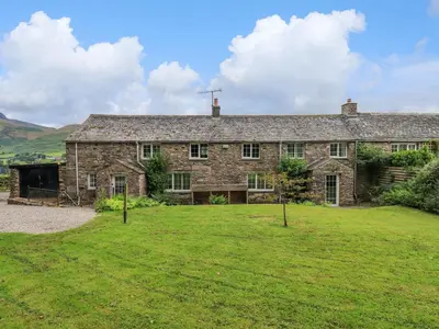 an old stone house with a large yard at Flaska House in Penrith
