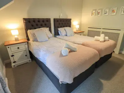 two beds in a bedroom with towels on them at Flaska House in Penrith