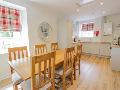 a kitchen and dining room with a wooden table and chairs at North Firbank - Culzean Castle in Maybole
