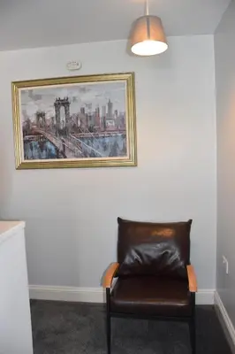 a chair in a room with a painting on the wall at Milo's place is a home from home in Egremont