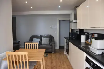 a kitchen and living room with a table and a couch at Milo's place is a home from home in Egremont