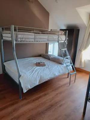 a bunk bed with a person laying on the bottom bunk at Voyage Hostel - Ensuite Family Rooms with shared kitchen in Douglas