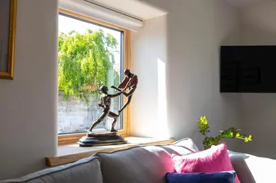 a statue sitting on a couch in front of a window at The Stables - Luxury Cottage in Dumfries