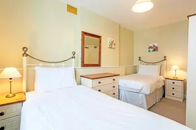 a bedroom with two beds and a mirror at Keswick View in Keswick