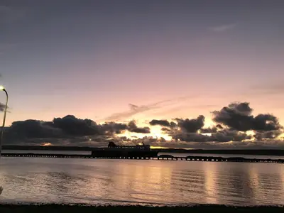a train on a bridge over the water at sunset at Cairnryan Bed and Breakfast in Cairnryan