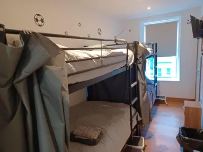 two bunk beds in a room with a window at Voyage Hostel - Rooms with Shared Kitchen in Douglas