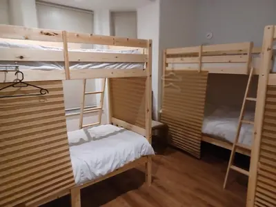 a room with two bunk beds in a room at Voyage Hostel - Rooms with Shared Kitchen in Douglas