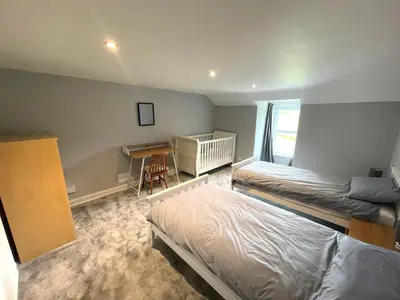 a bedroom with two beds and a desk in it at Spacious 3BR Cottage in Beautiful Rural Setting - Pass the Keys in Castle Douglas