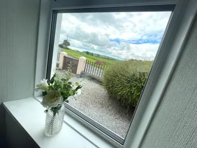 a window with a vase of flowers on a table at Spacious 3BR Cottage in Beautiful Rural Setting - Pass the Keys in Castle Douglas