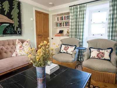 a living room with two chairs and a couch and a table at Auchengool House in Kirkcudbright