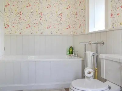 a bathroom with a toilet and a bath tub at Monkwood Cottage in Hale
