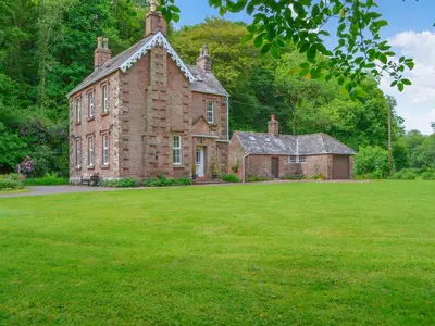 an old brick house with a large grass yard at Monkwood Cottage in Hale