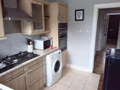 a kitchen with a stove and a washing machine at Lower Flat in Dumfries