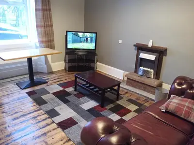 a living room with a couch and a television at Lower Flat in Dumfries