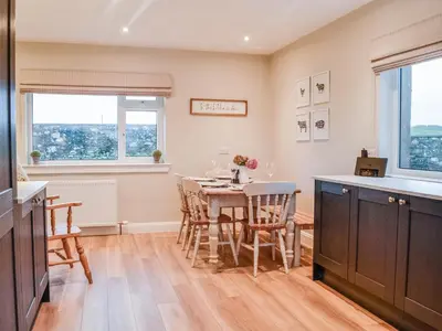 a kitchen and dining room with a table and chairs at Culbae Cottage in Whauphill