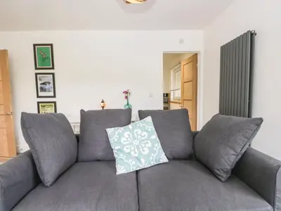 a gray couch with a pillow on it in a living room at Swaledale Watch House Annexe in Wigton