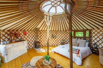 a room with a bed and a table in a yurt at The Kites Rest at Castle Creavie Farm in Kirkcudbright