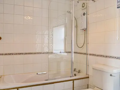 a bathroom with a shower and a tub and a toilet at Low Moat in Canonbie