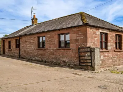 an old brick building with windows on a street at Low Moat in Canonbie