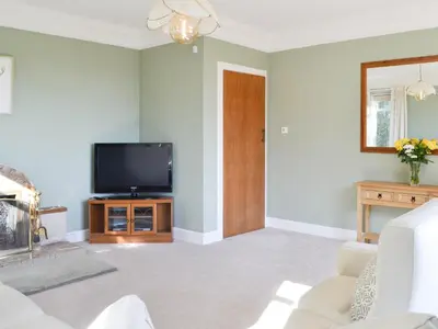 a living room with a television and a couch at Cairncroft Cottage in Colfin
