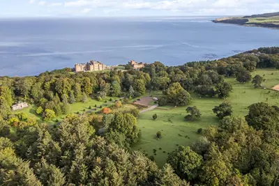 an aerial view of a castle on a hill next to the water at Garden House - Culzean Castle in Maybole