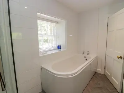a white bathroom with a tub and a window at Garden House - Culzean Castle in Maybole