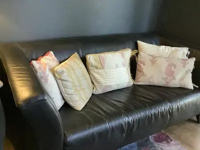 a leather couch with four pillows on it at Dobbin the horse box in The Lake District in Cockermouth