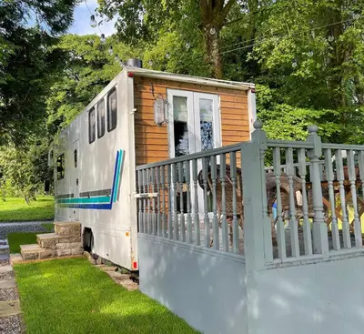 an old rv parked next to a fence at Dobbin the horse box in The Lake District in Cockermouth