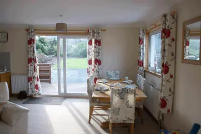 a dining room with a table and a window at 3 Bed Bungalow - Sleeps 6 - Pet Friendly - Parking in Drummore