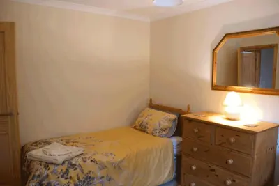a bedroom with a bed and a dresser and a mirror at 3 Bed Bungalow - Sleeps 6 - Pet Friendly - Parking in Drummore