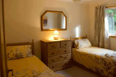 a bedroom with two beds and a dresser with a mirror at 3 Bed Bungalow - Sleeps 6 - Pet Friendly - Parking in Drummore