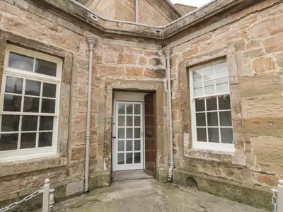 a brick building with a door and two windows at Clocktower - Culzean Castle in Maybole