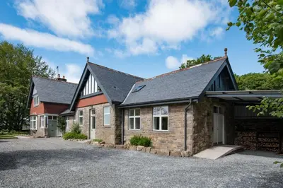 a house with a driveway in front of it at Beltie Lodge in Borgue