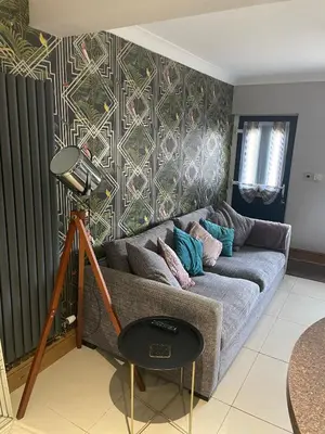 a living room with a couch and a lamp at Flosh Cottage Lake District in Cleator