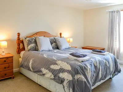 a bedroom with a bed with a blue and white bedspread at Mullhill in Ardwell