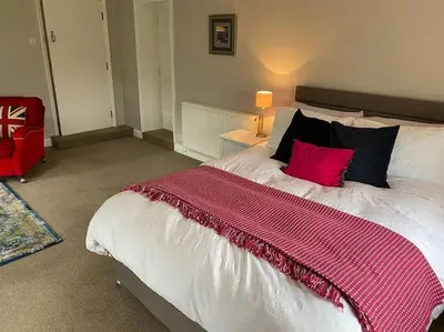 a bedroom with a large bed with a pink blanket at Kitty’s Place, Apartment, Eden Valley, Cumbria in Brampton