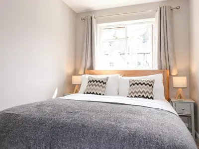 a bedroom with a bed with two pillows and a window at Dovestones in Keswick