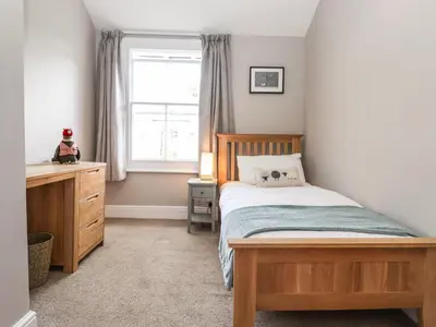 a bedroom with a bed and a dresser and a window at Dovestones in Keswick